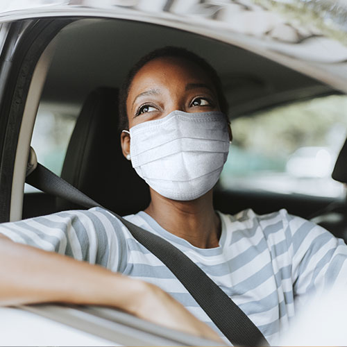 Woman waiting in car with mask